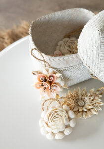 close up of white beaded basket with shell ornaments