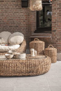 outdoor scene with baskets, couch and table from banana leafs