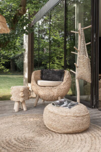 setting of pouffe, chair and pom pom stool in garden