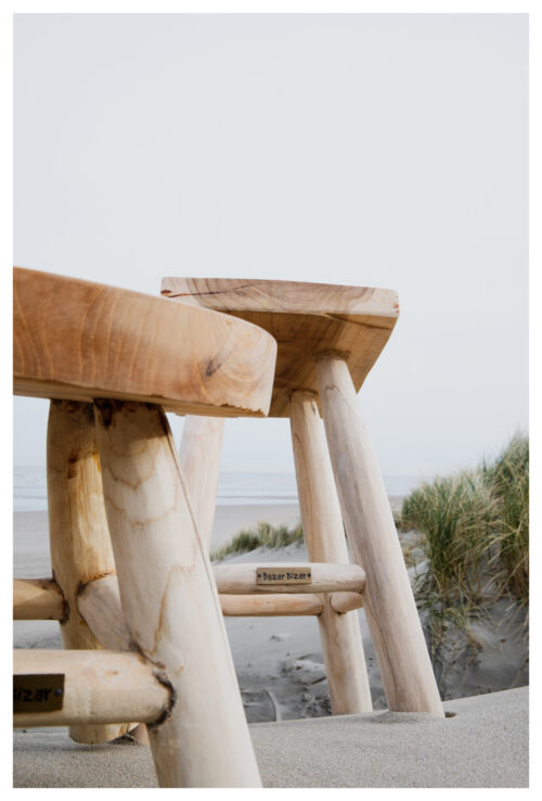 two wooden stools in the sand
