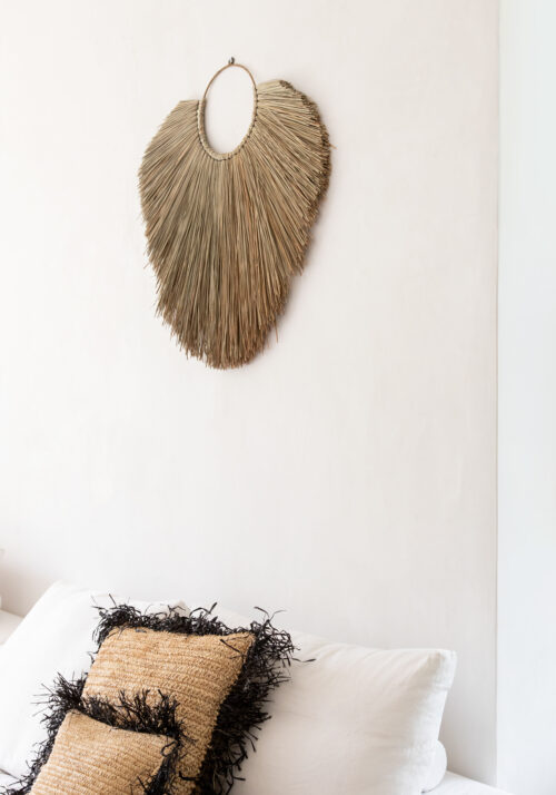 muur met wanddecoratie van gras en kussens op bed