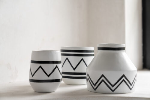 three white vases with black motif