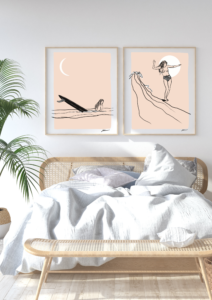 two prints of surfgirls in frame on wall
