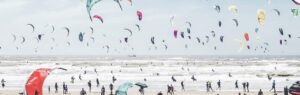 strand en zee vol met kitesurfers