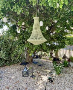 garden with green crochet chandelier hanging in a tree