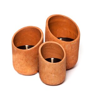 three terracotta candles on a white background