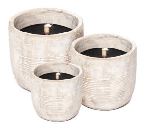 drie kaarsen in aardewerken pot in verschillende maten op witte achtergrond