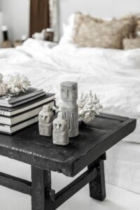 zandstenen beeldjes op zwarte tafel voor een bed geplaatst