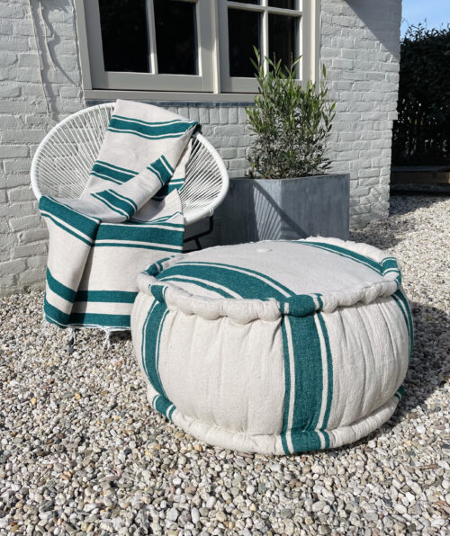 pouf and plaid on chair in garden.