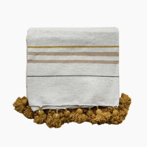folded pom pom blanket in off white with sand and ocher woven stripes