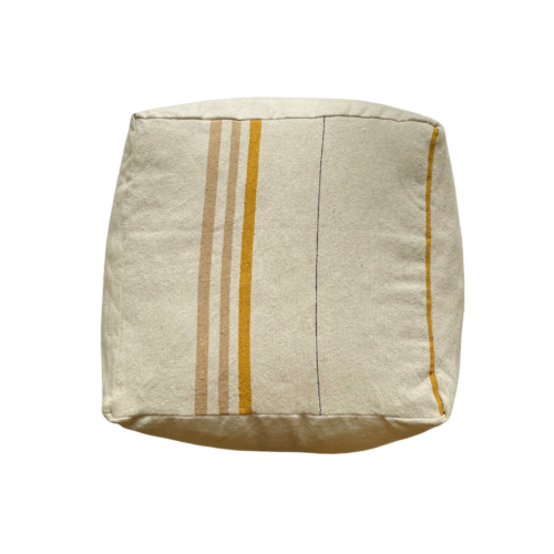 cream colored square pouf with gold and sand colored stripes photographed from above on white background