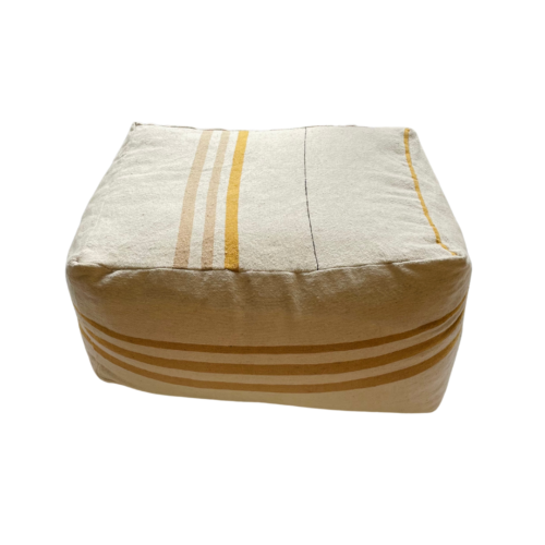cream colored pouf with gold and sand colored stripes photographed on a white background